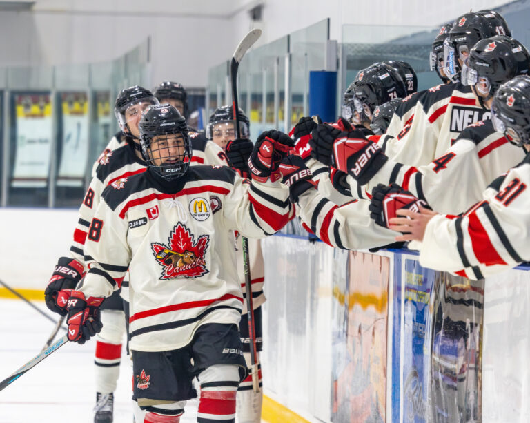 Jacob Greene celebrates a goal with his Niagara Falls Canucks teammates along the bench, 2026-27. (Photo by OJHL Images)